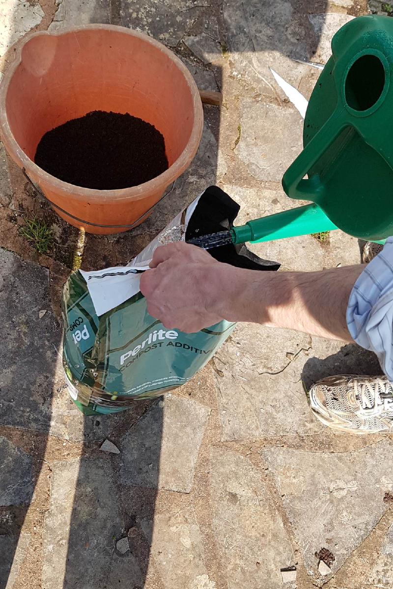 Add some water to the perlite to bind the dust particles.